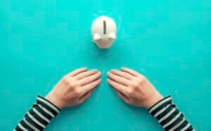 Woman's hands and piggy bank for The concept of savings. (Photo by IGOR STEVANOVIC / SCIENCE PHOTO / IST / Science Photo Library via AFP)