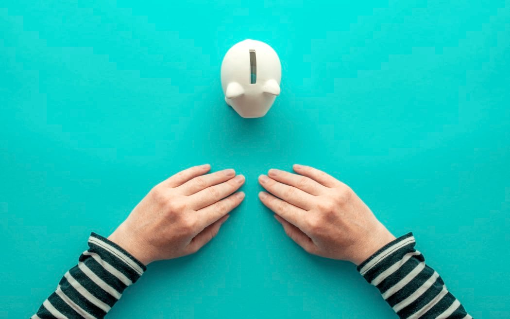 Woman's hands and piggy bank for The concept of savings. (Photo by IGOR STEVANOVIC / SCIENCE PHOTO / IST / Science Photo Library via AFP)